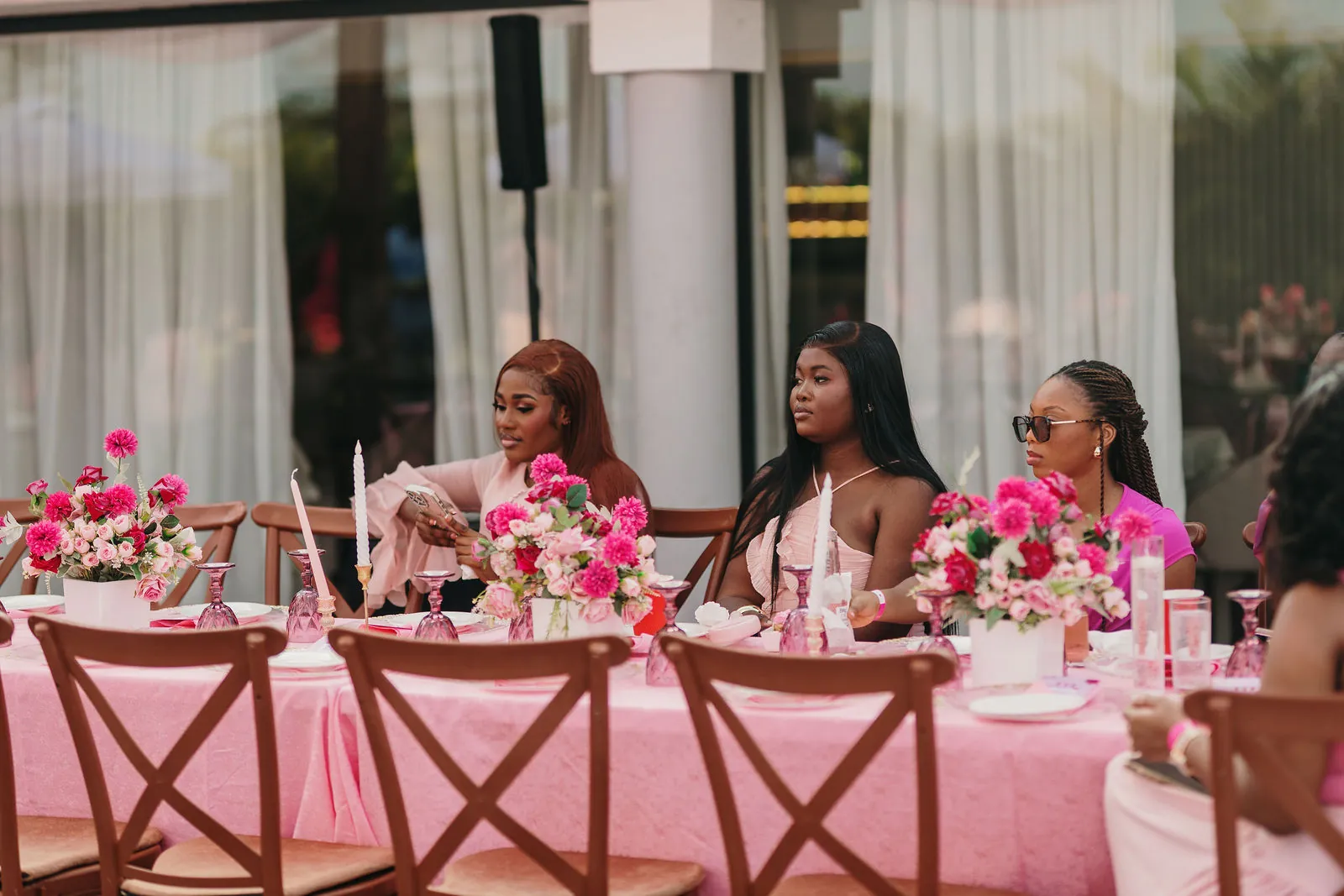 Guests dressed in pink seated along the long brunch table
